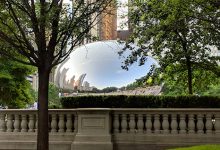 Chicago's Cloud Gate, or Bean, as seen from outside its pavilion with trees surrounding it.